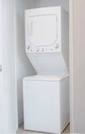 A room with a bed, a washer and dryer, and a lamp. AI generated content