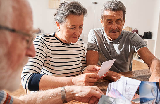 A man and a woman are sitting at a table, looking at a piece of paper. AI generated content