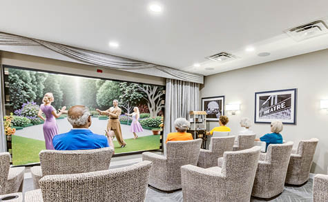 A group of people are sitting in a room with a large screen TV. AI generated content